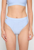 Hellblauer, hochgeschnittener Bikini-Bottom mit einem strukturierten geometrischen Muster und Ausschnitten an den Hüften. Glattes Material mit dehnbarem Schnitt.