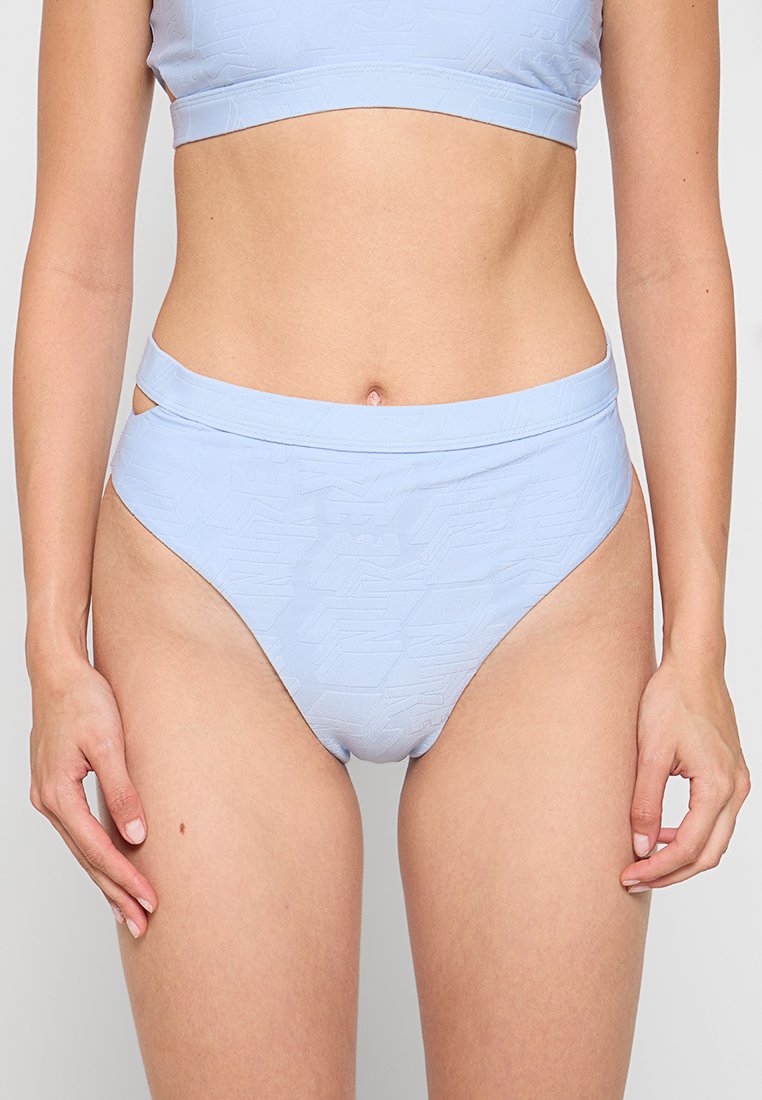 Hellblauer, hochgeschnittener Bikini-Bottom mit einem strukturierten geometrischen Muster und Ausschnitten an den Hüften. Glattes Material mit dehnbarem Schnitt.