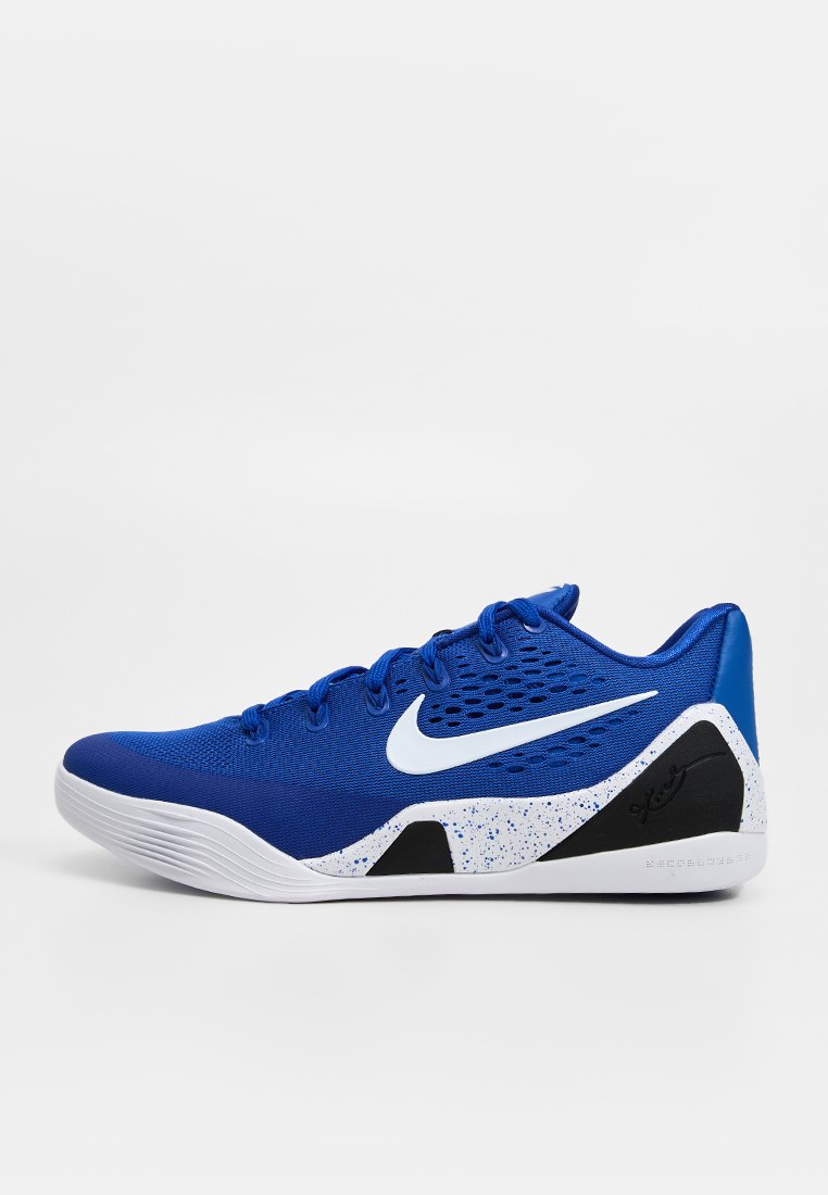 Blauer Nike Basketballschuh mit niedrigem Schaft, weißem Swoosh, gesprenkelter weißer Mittelsohle, schwarzen Akzenten und strukturierter Sohle auf weißem Hintergrund.