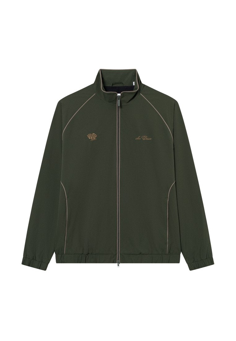 Dunkelgrüne Zip-Jacke aus strukturiertem Material, mit kontrastierenden beigen Paspeln und gesticktem Logo auf der Brust. Rippbündchen und Saum.