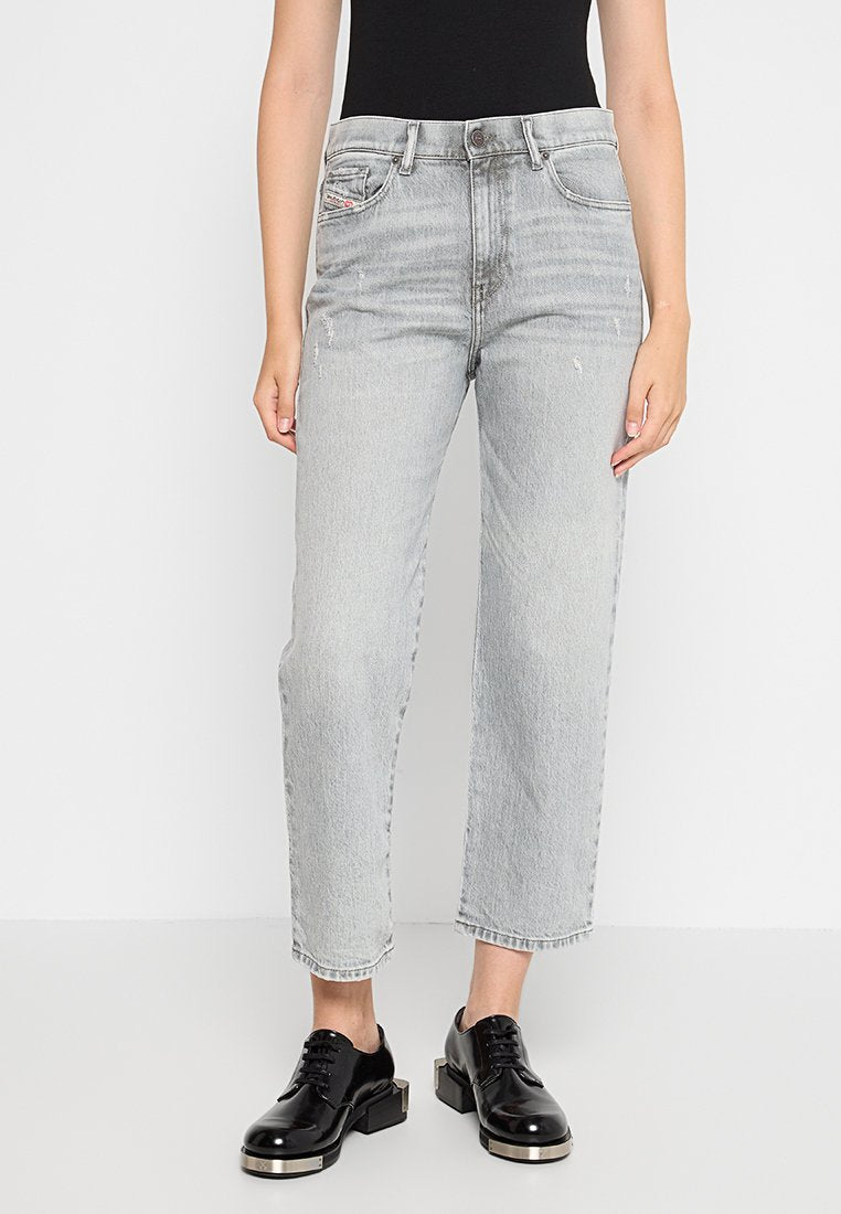 Helle graue, hochtaillierte Jeans mit geradem Bein, die dezente Used-Effekte und ein klassisches Fünf-Taschen-Design aufweisen. Kombiniert mit schwarzen Schuhen.