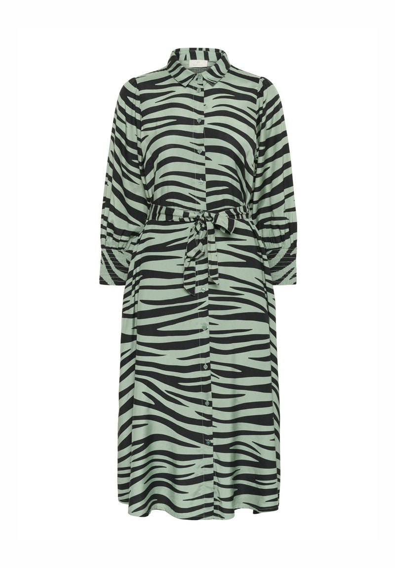 Langes grünes Kleid mit schwarzen Zebra-Streifen, mit einer durchgängigen Knopfleiste, Kragen und einem Bindegürtel in der Taille. Lange Ärmel mit geknöpften Manschetten.