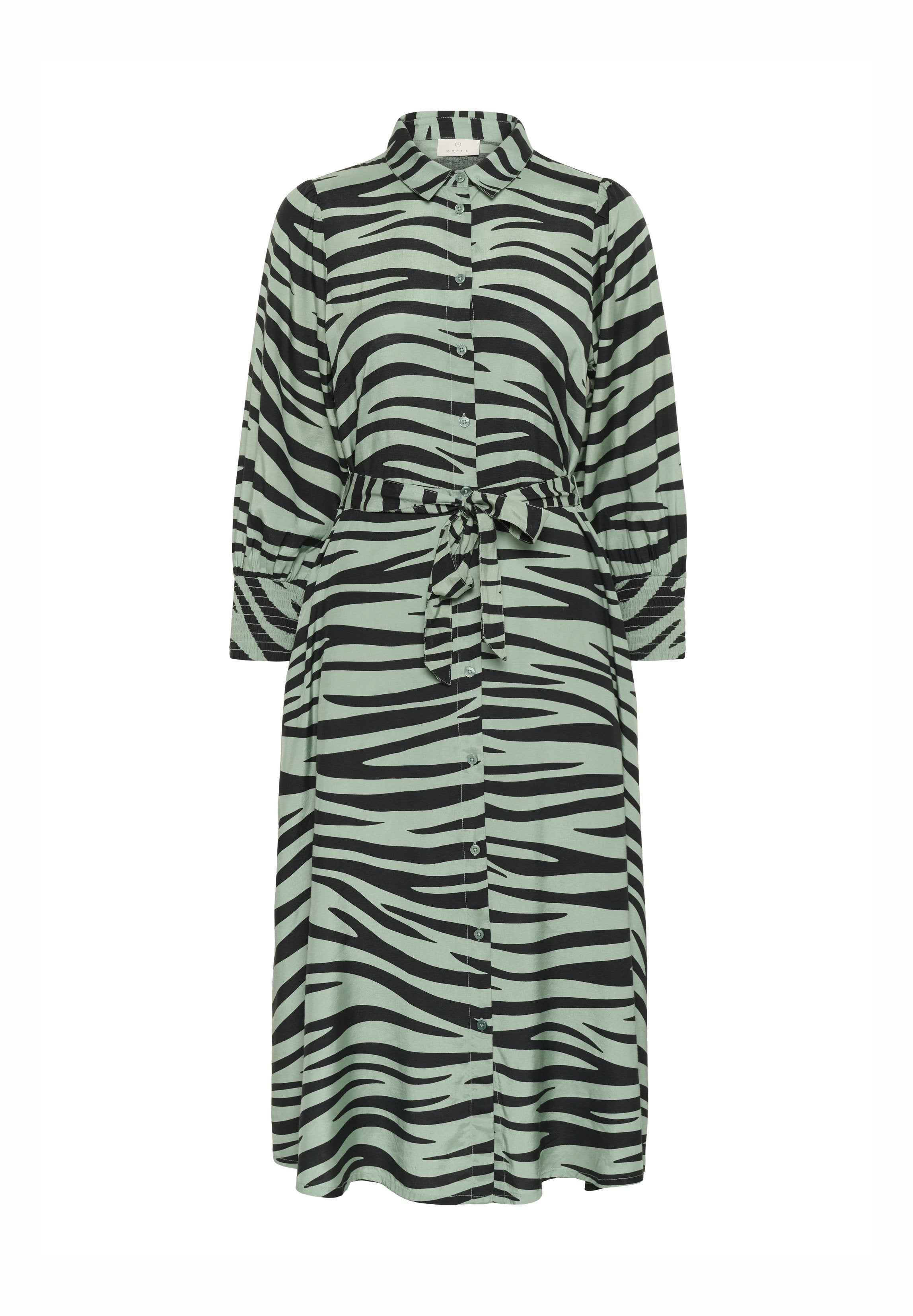 Langes grünes Kleid mit schwarzen Zebra-Streifen, mit einer durchgängigen Knopfleiste, Kragen und einem Bindegürtel in der Taille. Lange Ärmel mit geknöpften Manschetten.
