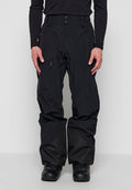 Mann trägt schwarze Schneehose mit Reißverschlusstasche am Oberschenkel und verstärktem Stoff an den unteren Beinen, kombiniert mit schwarzen Stiefeln und langärmligem Oberteil.