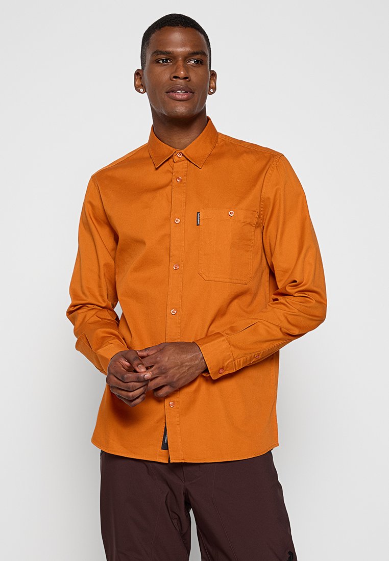 Oranges Button-Up-Hemd mit langen Ärmeln, Brusttasche und kontrastierenden Knöpfen. Hergestellt aus einem glatten, leichten Stoff.