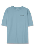 Hellblaues Baumwoll-T-Shirt mit lockerer Passform, kurzen Ärmeln und schwarzem "PEGADOR"-Logo auf der Brust. Weicher Stoff, keine zusätzlichen Muster.