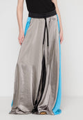 Weite Hosen mit glänzender metallic silberner Vorderseite, schwarzem Bund mit Kordelzug und blauen Seitenteilen. Zarte Textur und sportliches Design.