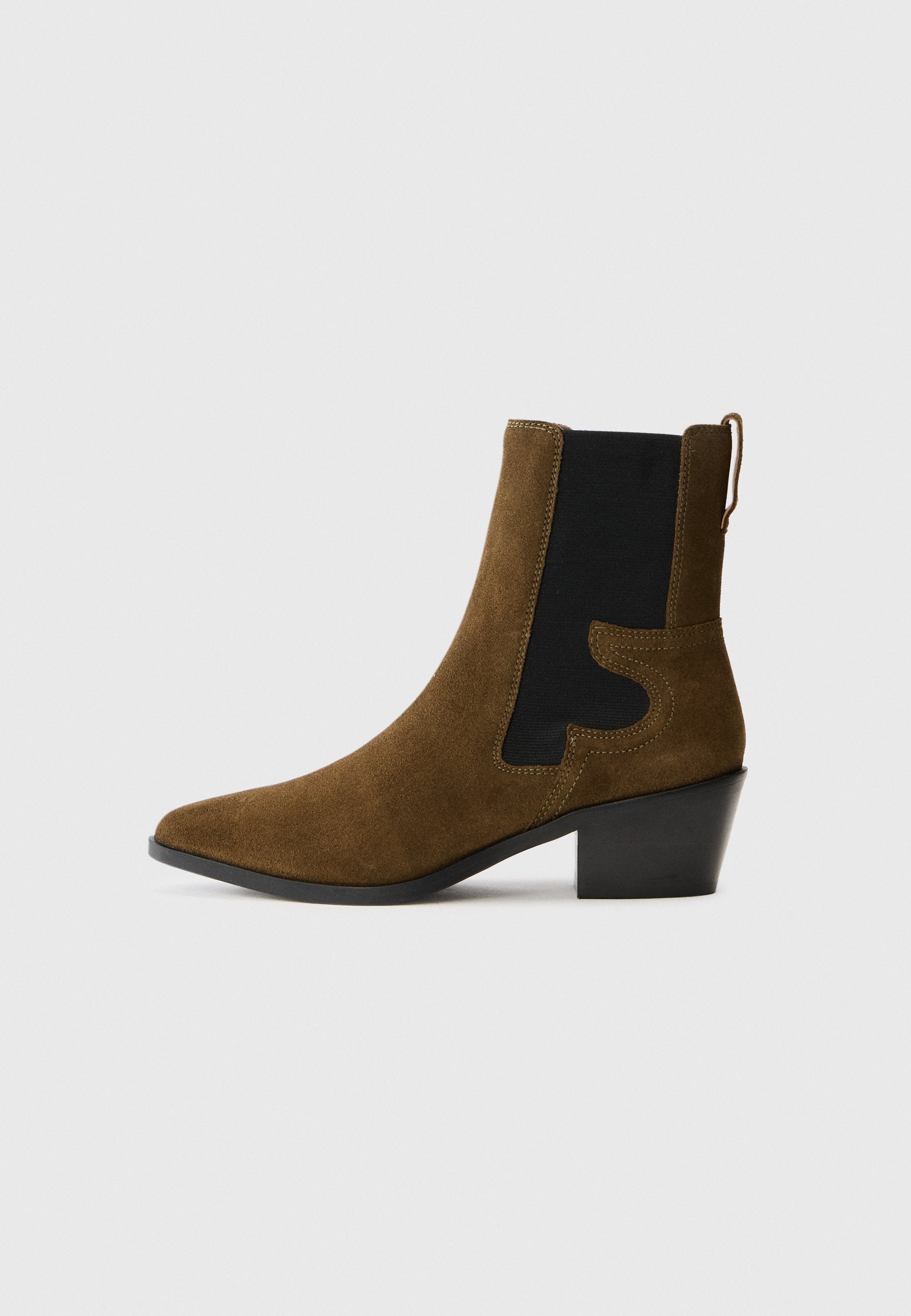 Braune Wildleder-Ankle Boots mit schwarzem elastischem Seitenpaneel und niedrigem Blockabsatz vor einem schlichten weißen Hintergrund.