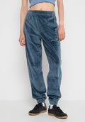Blaue Velours-Jogger mit elastischem Bund, schmal zulaufenden Bündchen und Seiten pockets, die ein dezentes Logo-Detail auf der Vorderseite aufweisen.