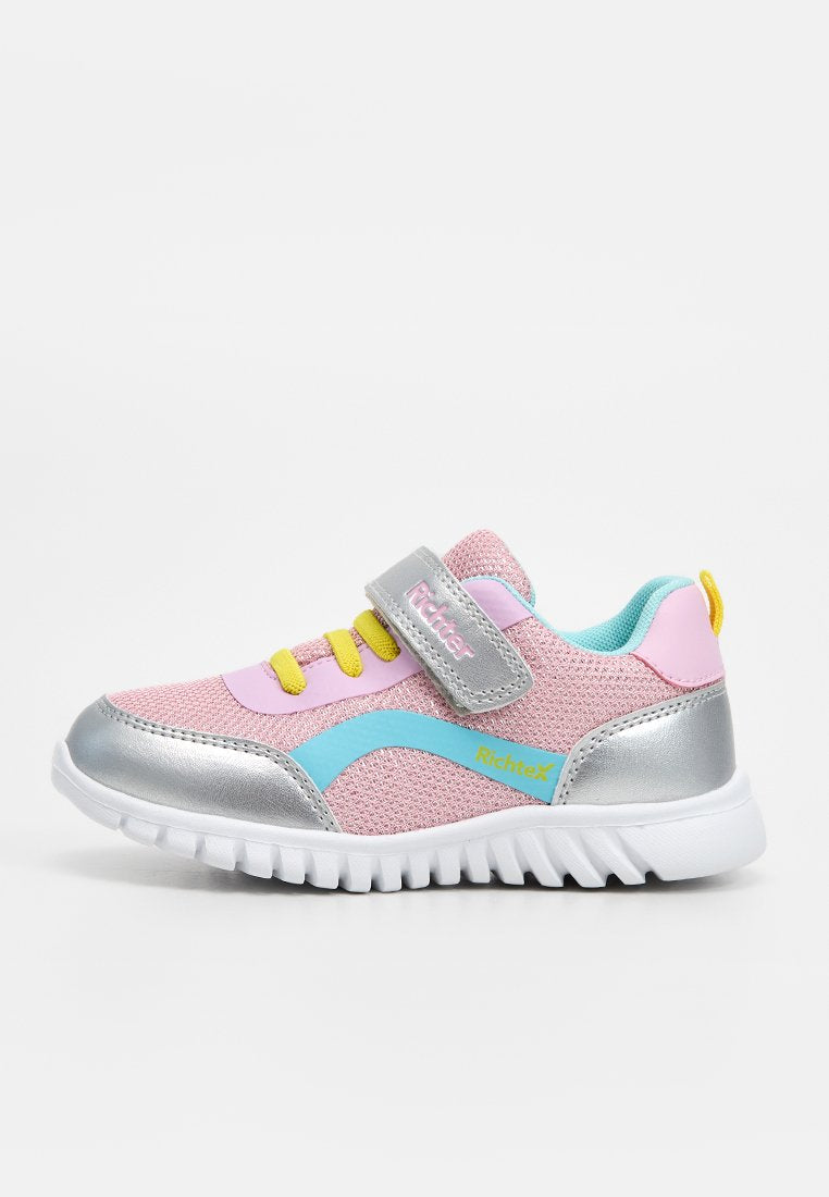 Kinder-Sneaker in Pink und Silber mit gelben Schnürsenkeln, blauen Details, Klettverschluss, blauem Innenfutter und weißer Sohle vor unifarbenem Hintergrund.