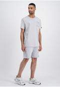 Helles graues T-Shirt mit kurzen Ärmeln, das drei strukturierte Taschen-Designs aufweist, kombiniert mit passenden hellgrauen Shorts und weißen Turnschuhen.