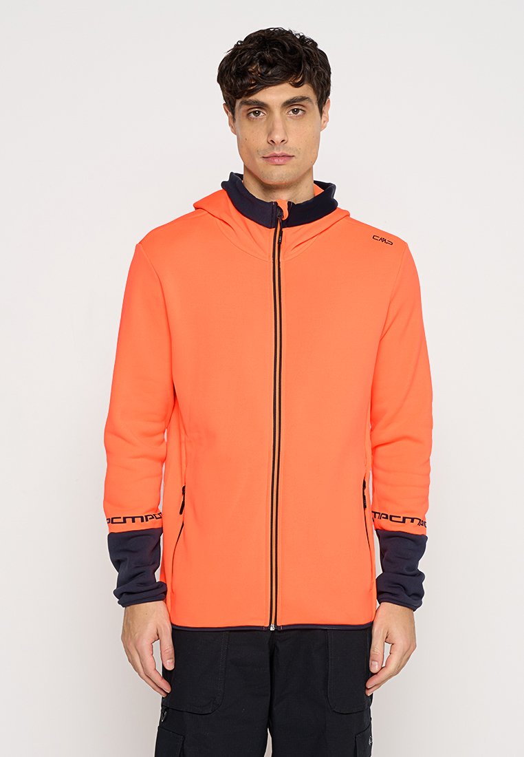 Helle orange Jacke mit Kapuze, ausgestattet mit einem durchgehenden Reißverschluss, kontrastierenden marineblauen Manschetten und Logo-Akzenten an den Ärmeln. Glatte Textur.