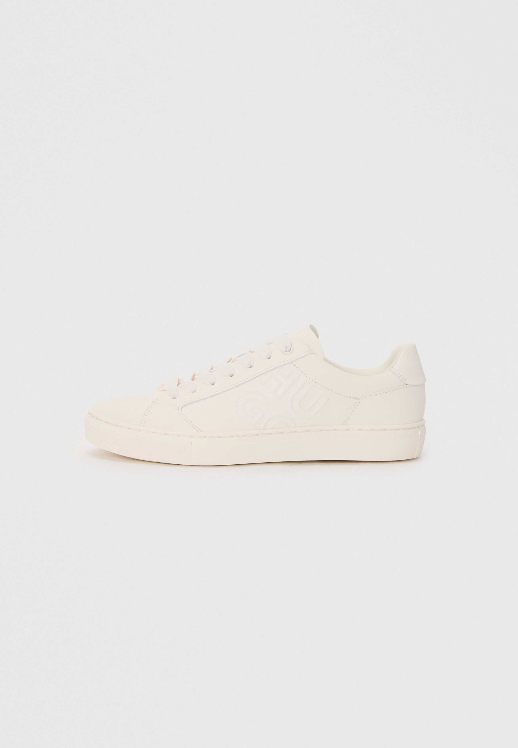 Sneaker aus cremefarbenem Leder mit geprägtem Logo-Design, runder Zehenpartie, flacher Sohle und sechs Ösen für Schnürsenkel.