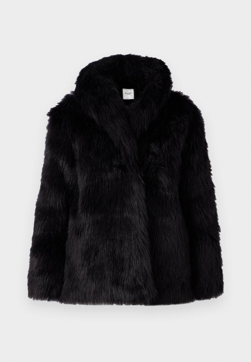 Schwarze Jacke aus Kunstfell mit strukturiertem Finish, ausgestattet mit einem breiten Kragen und einer offenen Vorderseite. Das Design ist lässig geschnitten und eignet sich gut zum Lagenlook.