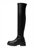 Knöchelhohe schwarze Stiefel aus glattem Synthetikleder, mit einer kräftigen Sohle und seitlichen Details, versehen mit einer Naht entlang der oberen Kante.