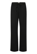 Schwarze weit geschnittene Hose aus weichem, dehnbarem Material. Sie hat einen elastischen Bund mit Kordelzug. Einfaches Design, keine Muster oder Akzente.