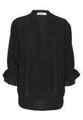 Schwarze Bluse mit langen Ärmeln aus strukturiertem Stoff mit dezenten metallischen Fäden. Hat rüschierte Manschetten und einen asymmetrischen Saum.