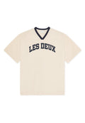 Naturweißes Mesh-V-Ausschnitt-T-Shirt mit kurzen Ärmeln, verziert mit marineblauer Einfassung und dem Schriftzug "LES DEUX" in fettgedruckten marineblauen Buchstaben auf der Brust.