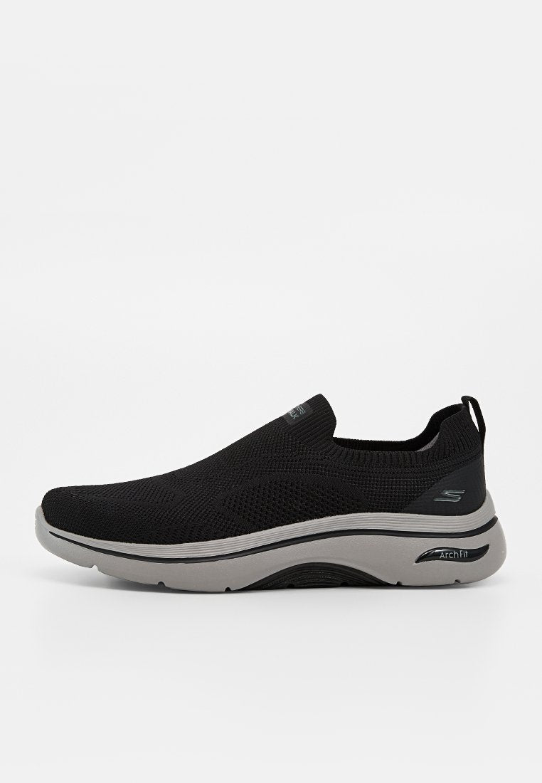 Schwarzer Slip-On Sneaker mit gestricktem Obermaterial, grauer gepolsterter Sohle und "Arch Fit"-Label an der Seite.