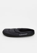 Schwarzer, gepolsterter Slipper zum Hineinschlüpfen mit gesteppter Optik, rundem Zehenbereich und "Peak Performance"-Logo an der Seite.