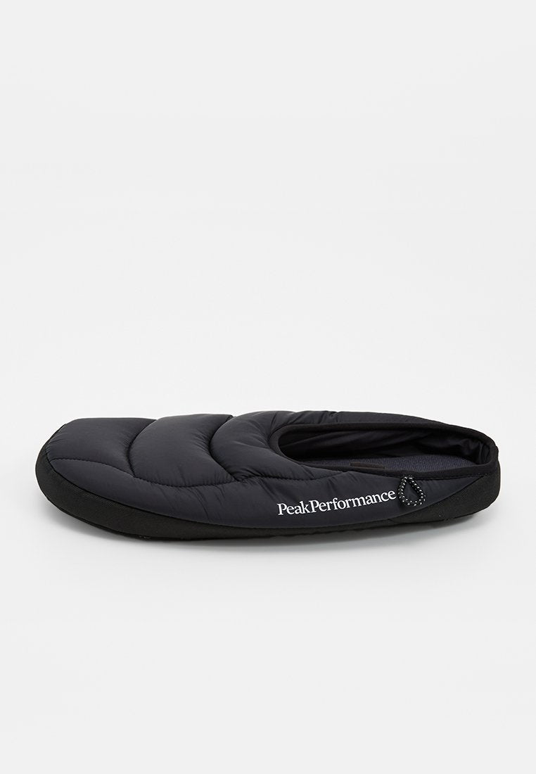Schwarzer, gepolsterter Slipper zum Hineinschlüpfen mit gesteppter Optik, rundem Zehenbereich und "Peak Performance"-Logo an der Seite.