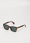 Schildpatt-Sonnenbrille mit quadratischen Gläsern, dunkelgrünem Farbton und strukturierten Bügeln. Merkmale feine vertikale Streifen an der Fassung.