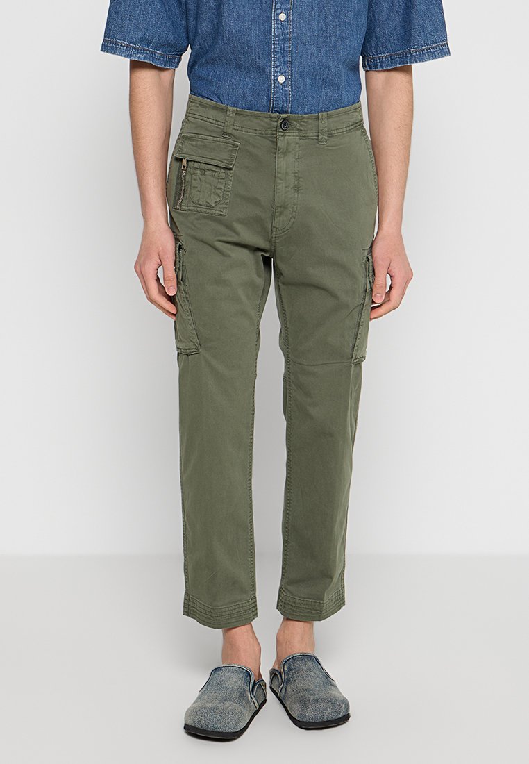 Olivegrüne Cargo-Hosen mit Seitentaschen, einer Reißverschlusstasche und tapered Cuffs. Hergestellt aus strapazierfähigem Baumwollmaterial mit einer glatten Textur.