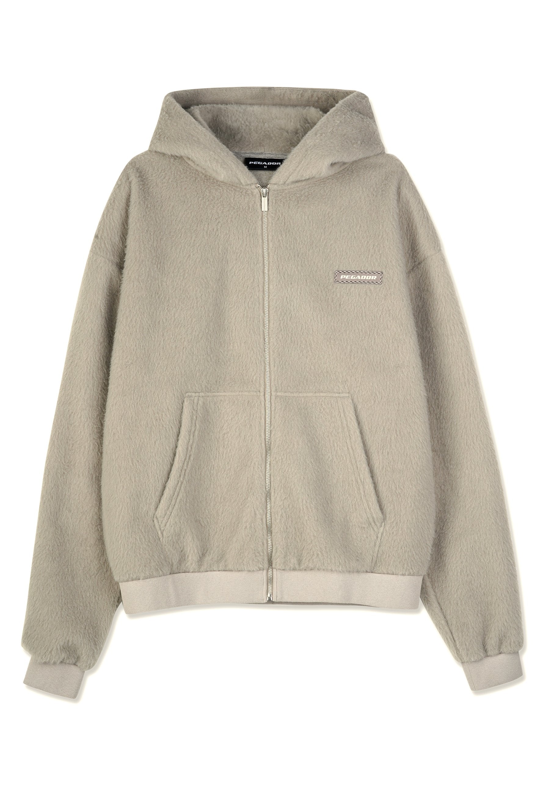 Fleece-Kapuzenjacke in Hellgrau mit Frontreißverschluss, zwei Fronttaschen, gerippten Bündchen und einem kleinen Logopatch auf der Brust.
