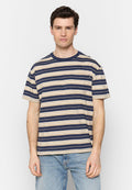 Mann steht da und trägt ein navyblaues, beiges und weiß gestreiftes T-Shirt mit kurzen Ärmeln und einer Brusttasche sowie eine hellblaue Jeans.