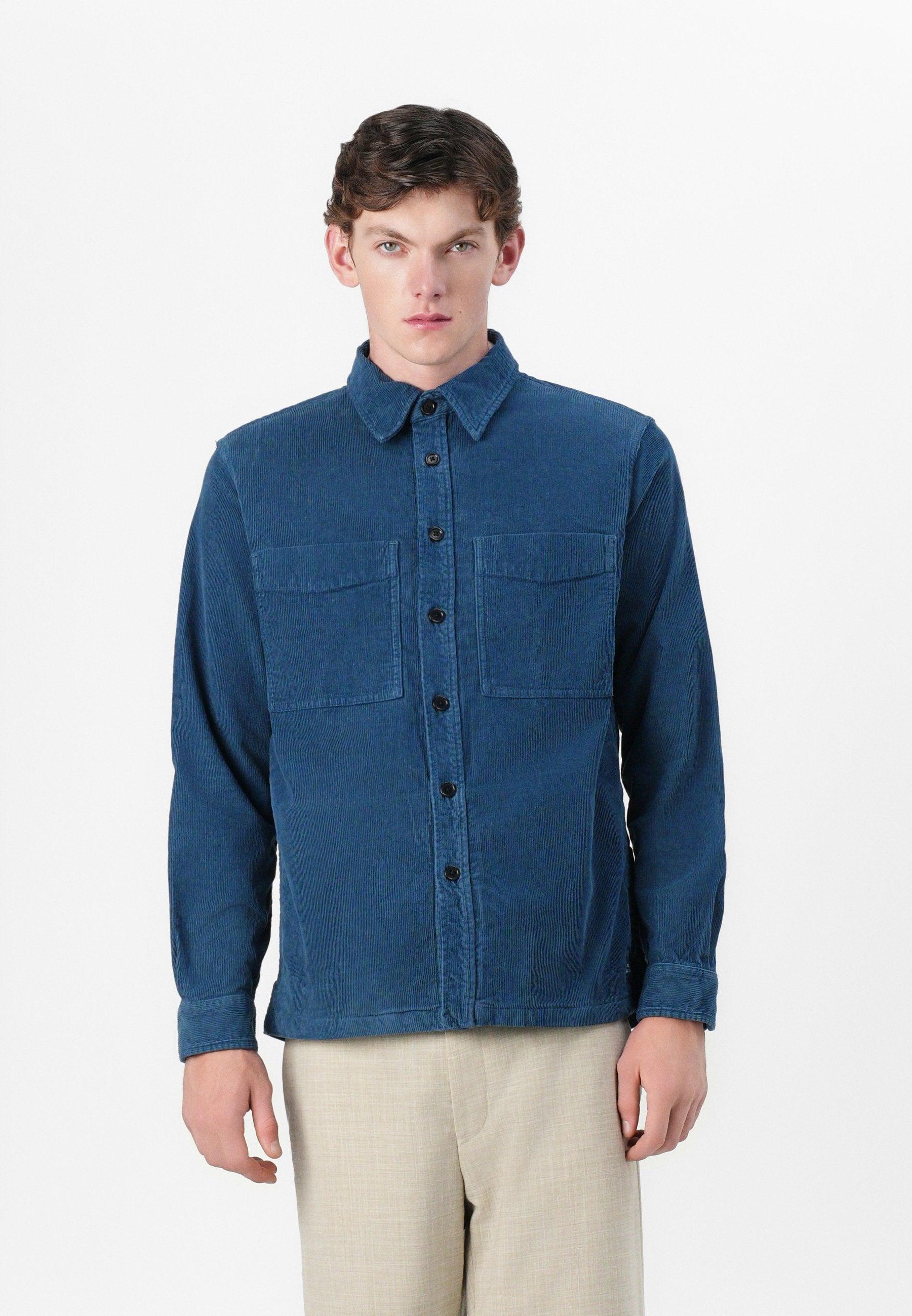 Blaue Cordhemd mit Knopfverschluss, zwei Brusttaschen und langen Ärmeln. Verfügt über einen klassischen Kragen und schwarze Knöpfe.