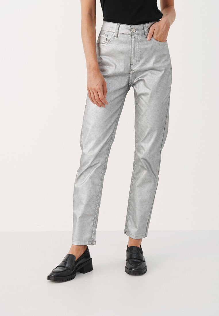 Silberne metallische Jeans mit geradem Schnitt, hoher Taille und Five-Pocket-Design. Glatte Textur mit leichtem Glanz, kombiniert mit schwarzen Slippern.