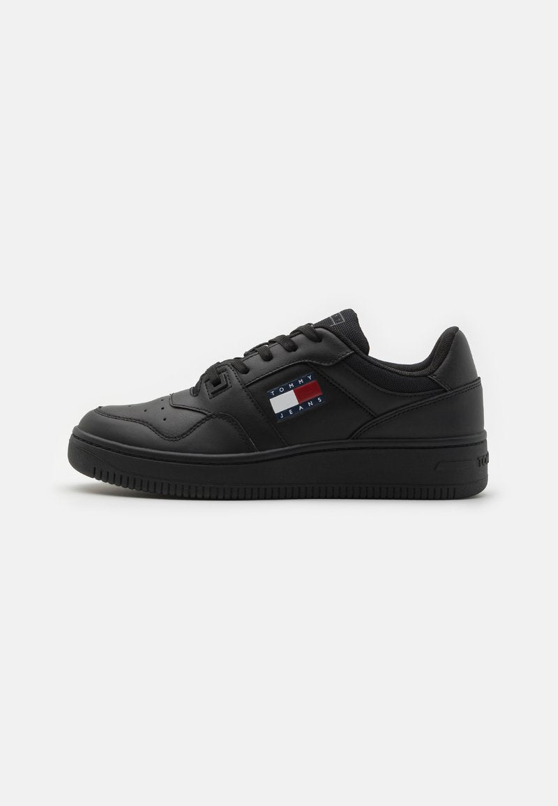 Schwarze Leder-Sneaker mit niedrigem Profil, runder Spitze, gepolstertem Kragen und strukturierter Gummisohle. Verfügt über ein Logo-Patch in Rot, Weiß und Blau.