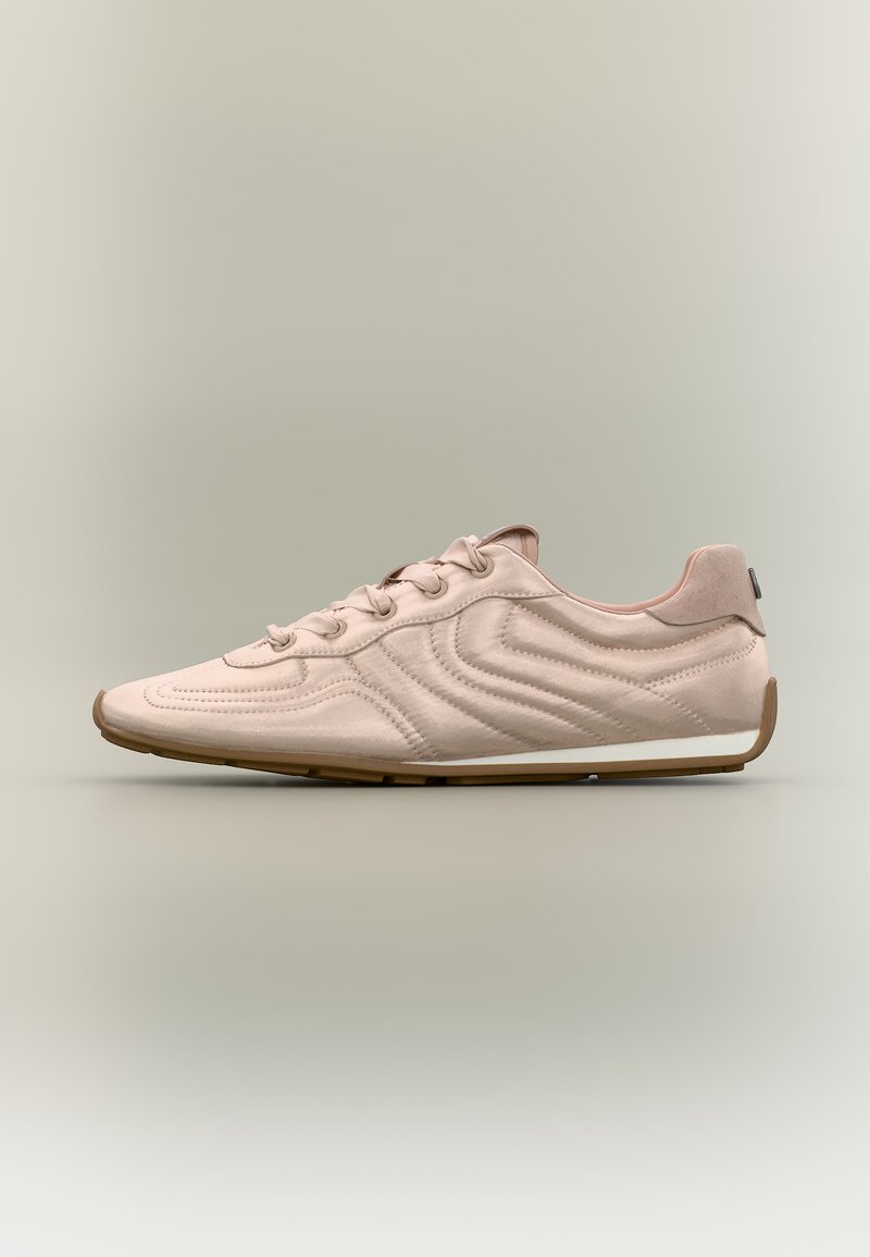 Hellrosa Wildledersneaker mit wellenförmiger Steppnaht, Schnürung vorne und Gummisohle vor neutralem Hintergrund.