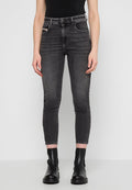 Schwarze Skinny-Jeans mit subtiler Ausbleichung, hoher Taille, Fünf-Taschen-Design, ausgefranster Saum, kombiniert mit schwarzen Knöchelschuhen. Glatte Denim-Textur.