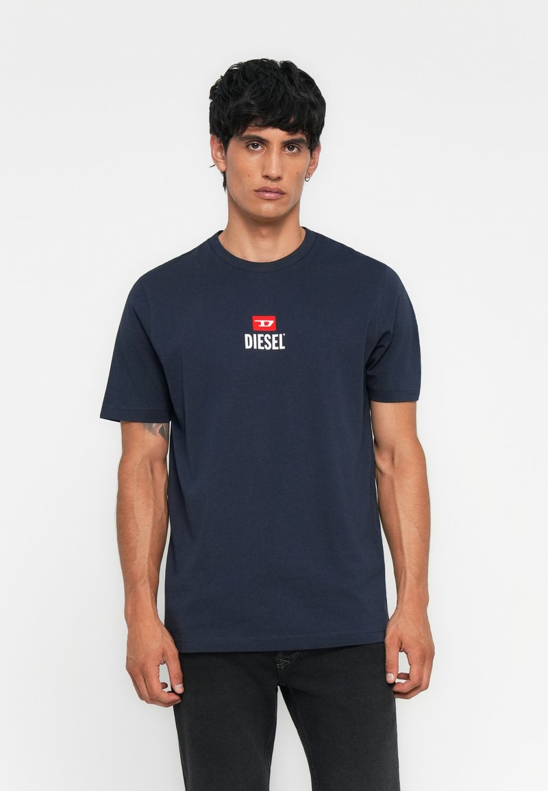 Navyblaues Baumwoll-T-Shirt mit einem runden Halsausschnitt und kurzen Ärmeln. Zentrales Logo in Rot und Weiß mit der Aufschrift "DIESEL."