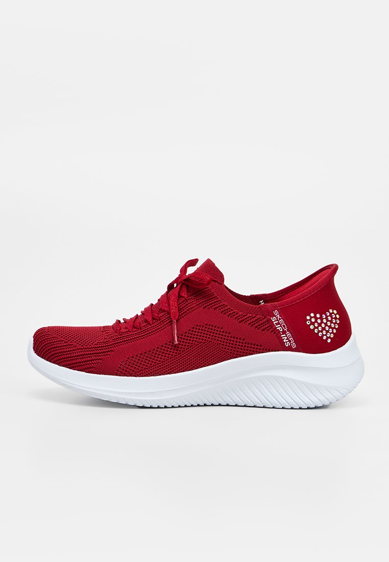 Roter gestrickter Sneaker mit weißer Sohle, Schnürung vorne, Skechers Slip-ins Branding und einem Strassherz-Detail an der Ferse.