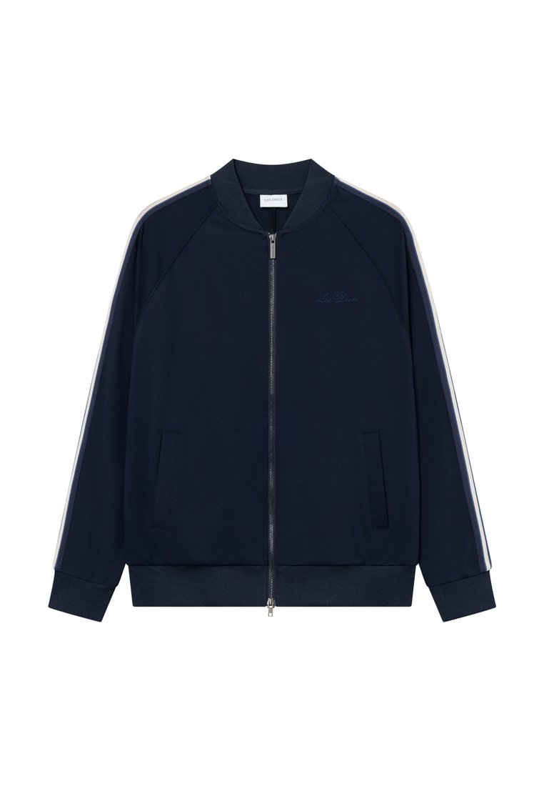 Marineblaue Zip-Jacke mit Raglanärmeln, zwei Fronttaschen und weißen Seitenstreifen. Mit einem gerippten Kragen und subtilen Logodetails.