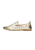 Goldfarbenes, flaches Schuhmodell mit abgerundetem Zehenbereich, das ausgestanzte kreisförmige Muster und einen flexiblen, elastischen Fersenteil aufweist. Glatte Oberfläche, minimalistisches Design.