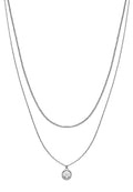 Silberfarbener, mehrschichtiger Halsreifen mit zwei Ketten unterschiedlicher Längen, mit einem Anhänger, der ein kreisförmiges Design in der Mitte zeigt.