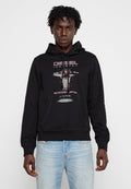 Schwarzer Hoodie aus Baumwolle, mit grafischem Druck auf der Vorderseite, Kapuze mit Kordelzug und einer Kängurutasche. Kombiniert mit hellblauen Jeans.