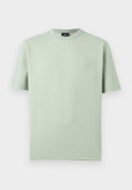 Hellgrünes T-Shirt mit kurzen Ärmeln und Rundhalsausschnitt, mit dezentem geometrischem Muster und einem schwarzen Etikett am Halsausschnitt.