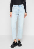 Helleblaue High-Waist Straight Jeans, kombiniert mit einem schwarzen Langarmshirt und klobigen schwarzen Plateauschnürschuhen, stehend vor einem weißen Hintergrund.