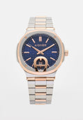 Aigner-Uhr mit strukturiertem navy-blauen Zifferblatt, roségoldenen Akzenten, silbernem Edelstahlarmband und einem Datumsdisplay um 6 Uhr.