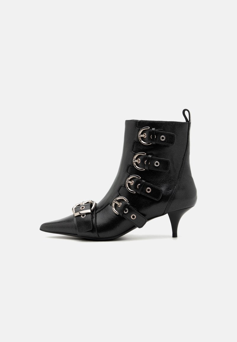 Schwarze Leder-Stiefelette mit spitzem Zehenbereich, ausgestattet mit fünf Riemen und silbernen Schnallen, einem Kittenheel und einer Schlaufe an der Rückseite für ein einfaches Anziehen.