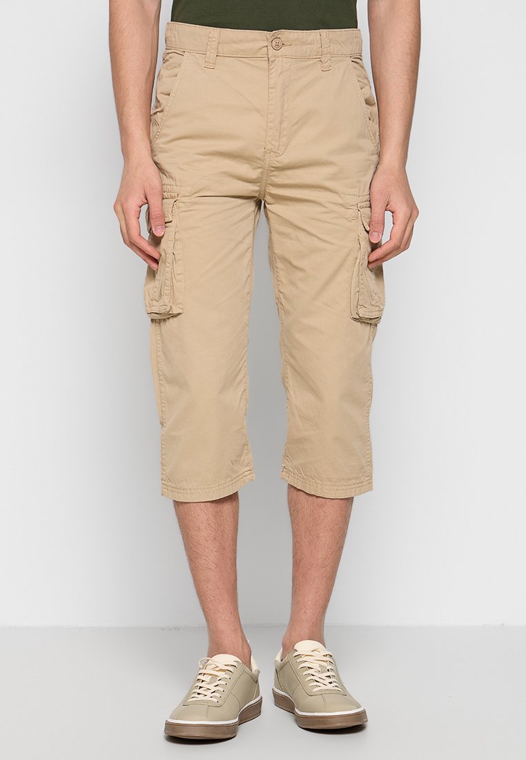 Beige Cargo-Shorts mit knie-langer Schnitt, ausgestattet mit Seitentaschen und einer lässigen Passform. Der Stoff wirkt leicht und hat eine dezente Textur.
