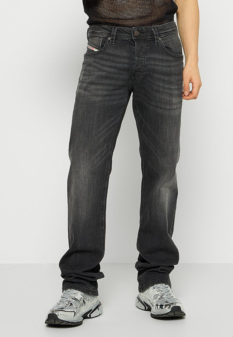 Dunkelgraue Jeans aus Denim mit geradem Bein, subtiler ausgebleichter Textur und vorderen sowie hinteren Taschen. Mit einem kleinen Label akzentuiert.