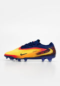 Nike-Sportschuh mit Farbverlauf von Gelb zu Rot-Gelb, strukturiertem synthetischem Material, marineblauen Akzenten und sechs Stollen an der Außensohle.