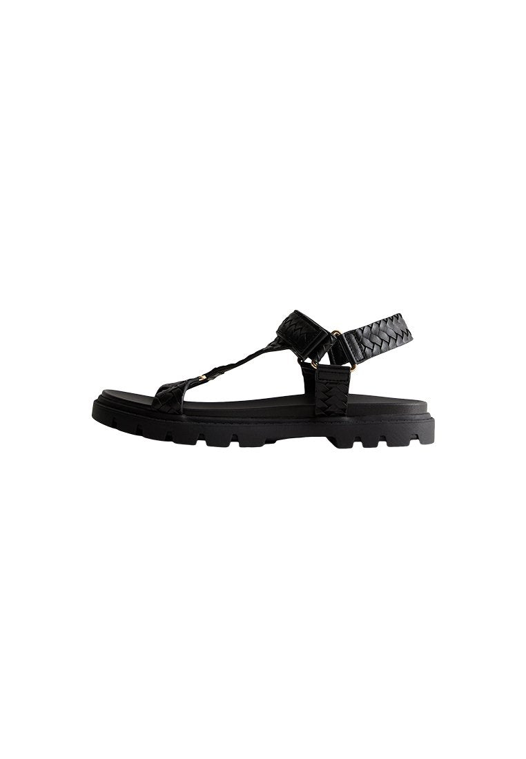 Schwarze Sandale mit geflochtenen oberen Riemen, verstellbarem Knöchelriemen und kräftiger Gummisohle. Verfügt über ein minimalistisches Design und strapazierfähiges Material.