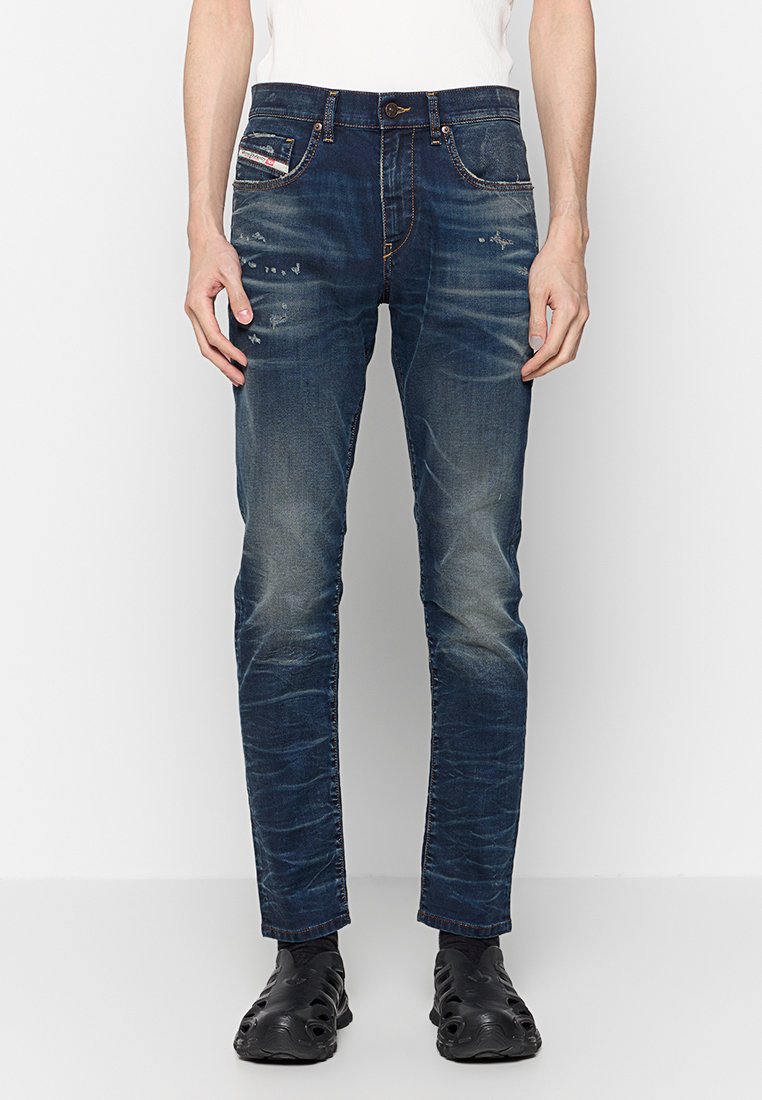 Slim-Fit blaue Denim-Jeans mit ausgebleichten Stellen, distressed Details, klassischem Fünf-Taschen-Design und Knopfverschluss.