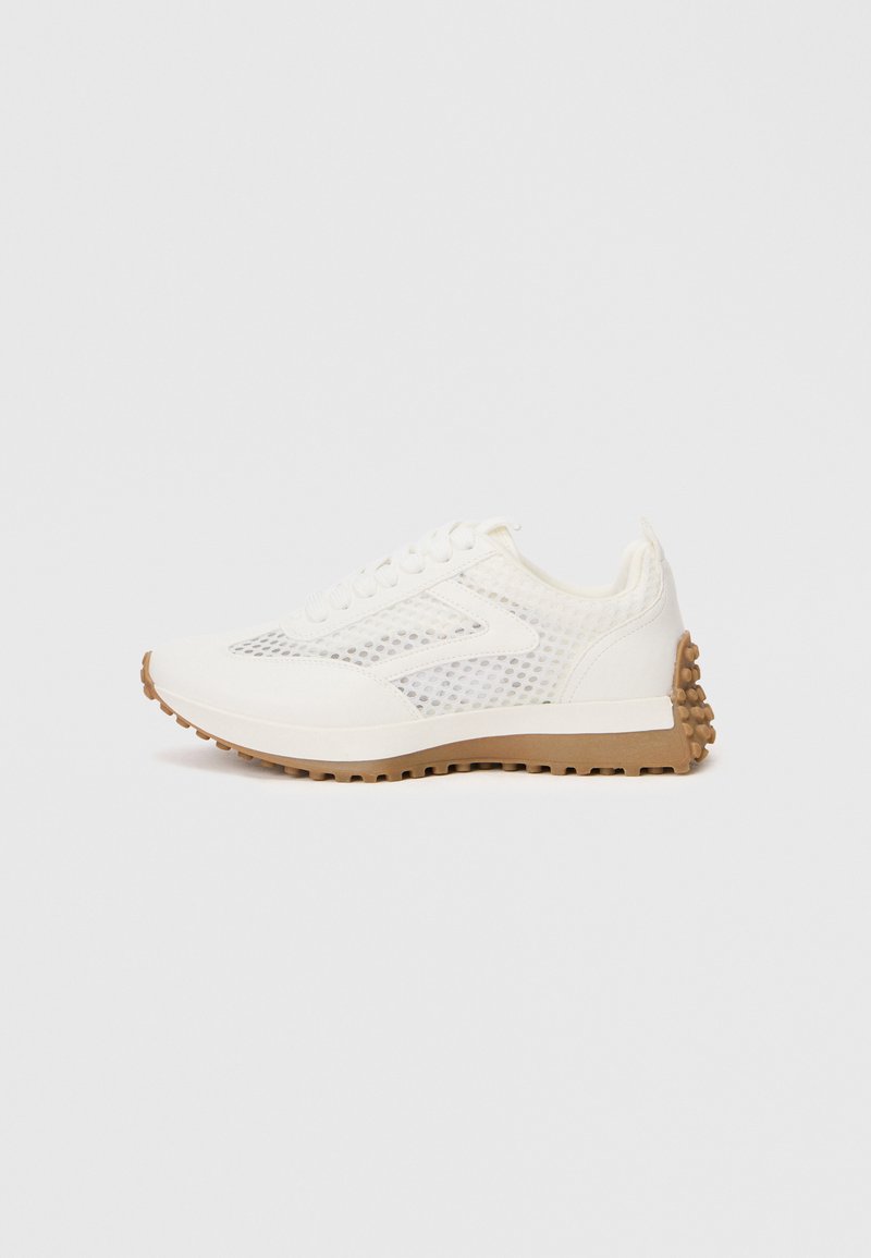 Weißer Sportschuh mit Mesh-Akzenten, runder Zehenpartie und beiger Gummisohle mit strukturierten Grip-Pads. Schnürdesign mit sechs Ösen.